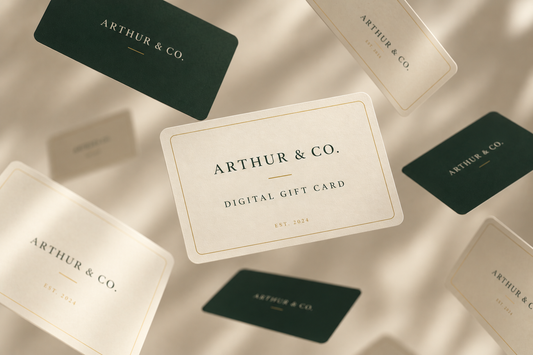 Floating Arthur & Co. digital gift cards in cream and dark green tones on a softly lit beige background.